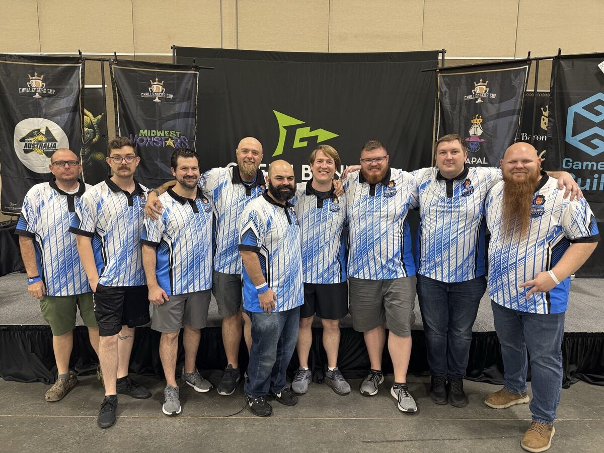 Smite Club's travel team in club jerseys in front of Challengers Cup banners