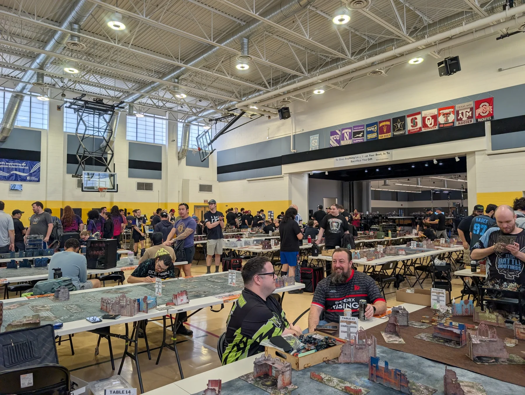Smite Club members smiling together beside active tournament tables